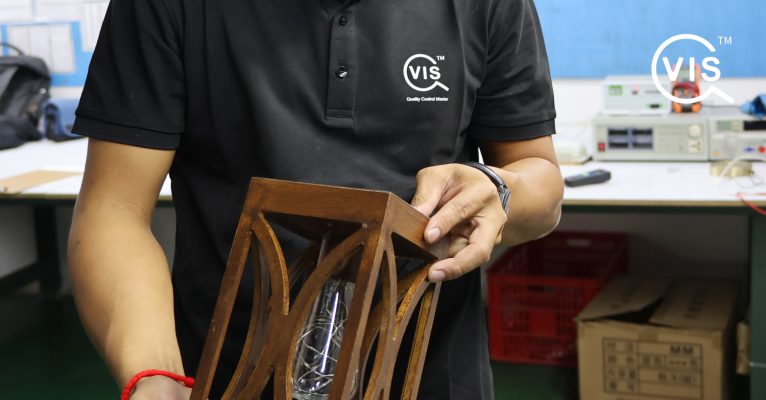 vis-global-inspector-holding-a-wooden-lamp.jpeg